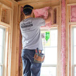 Man installing fiberglass wall insulation