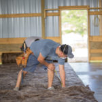 Workers measuring insulation on the floor of a large commercial space.