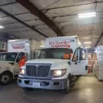 Rockweiler warehouse with two trucks and piles of insulation products.
