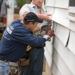 Two workers at a sidewall insulation project.