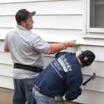 Exterior side wall work by two Rockweiler Insulation workers.