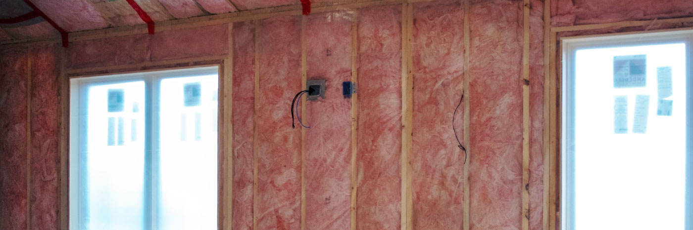 Fiberglass batt wall insulation in a room with windows.