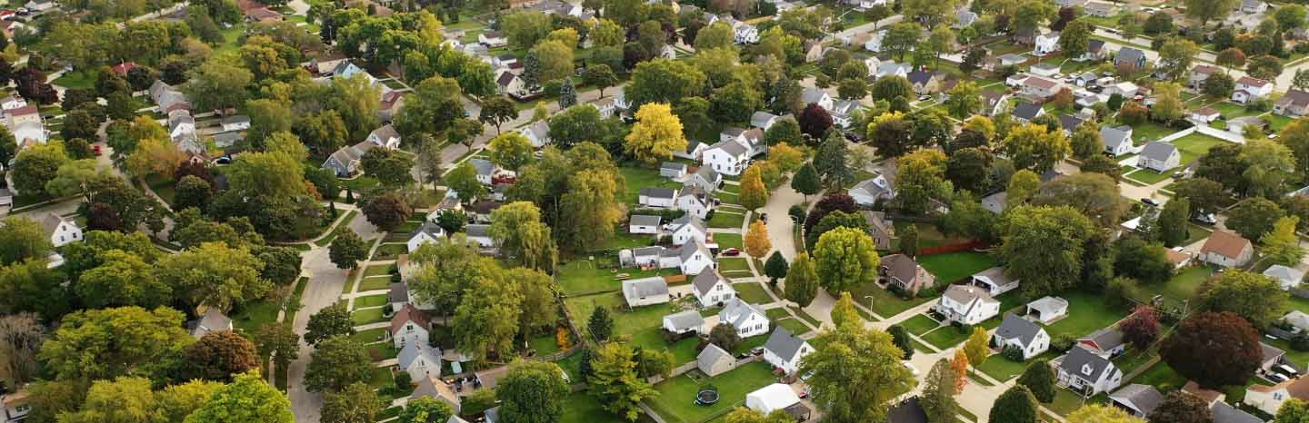 Aerial drone view of American suburban neighborhood. Establishing shot of America's suburb. Residential single family houses pattern.